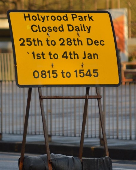 Road sign giving park closure times